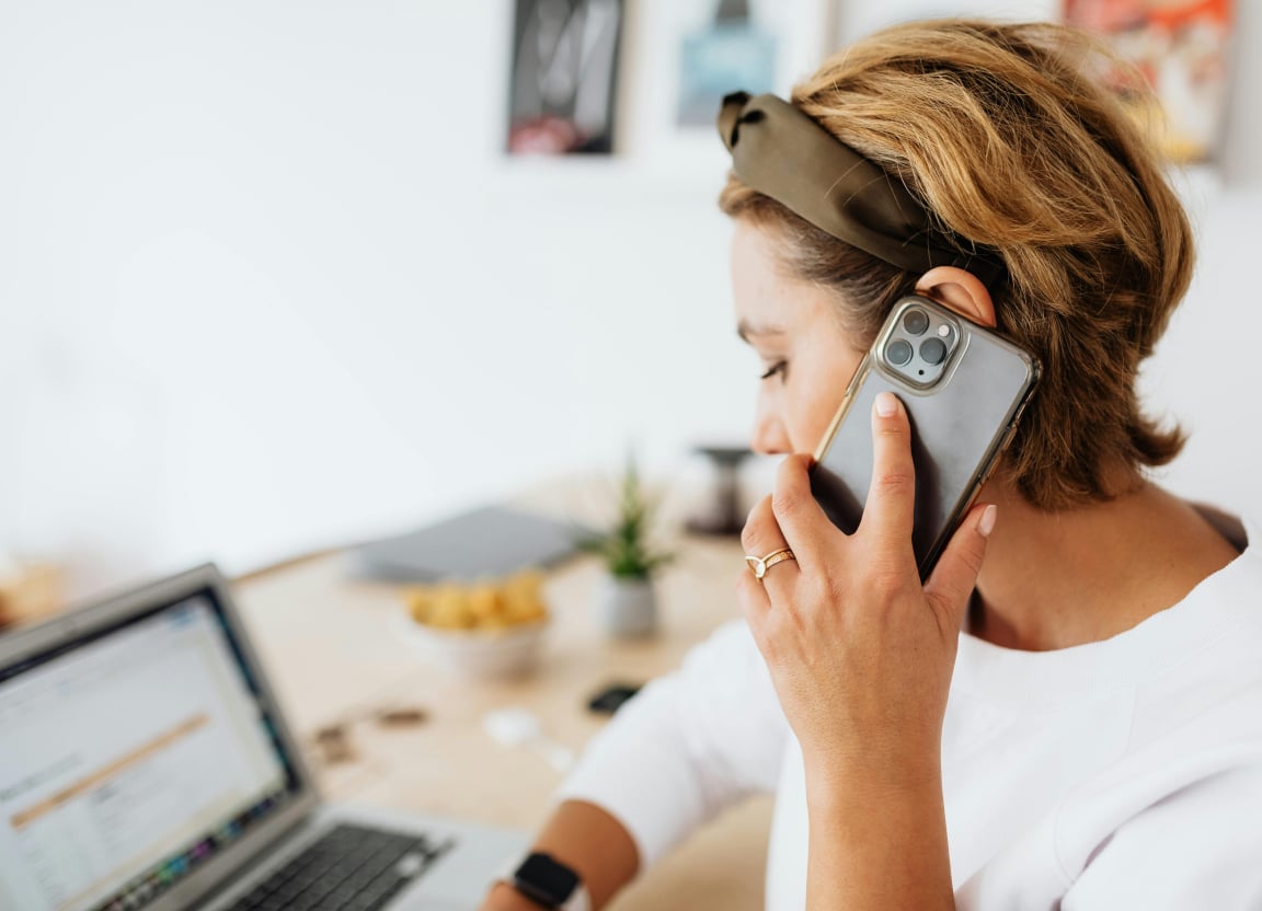 Employee taking a call and working on a laptop at home